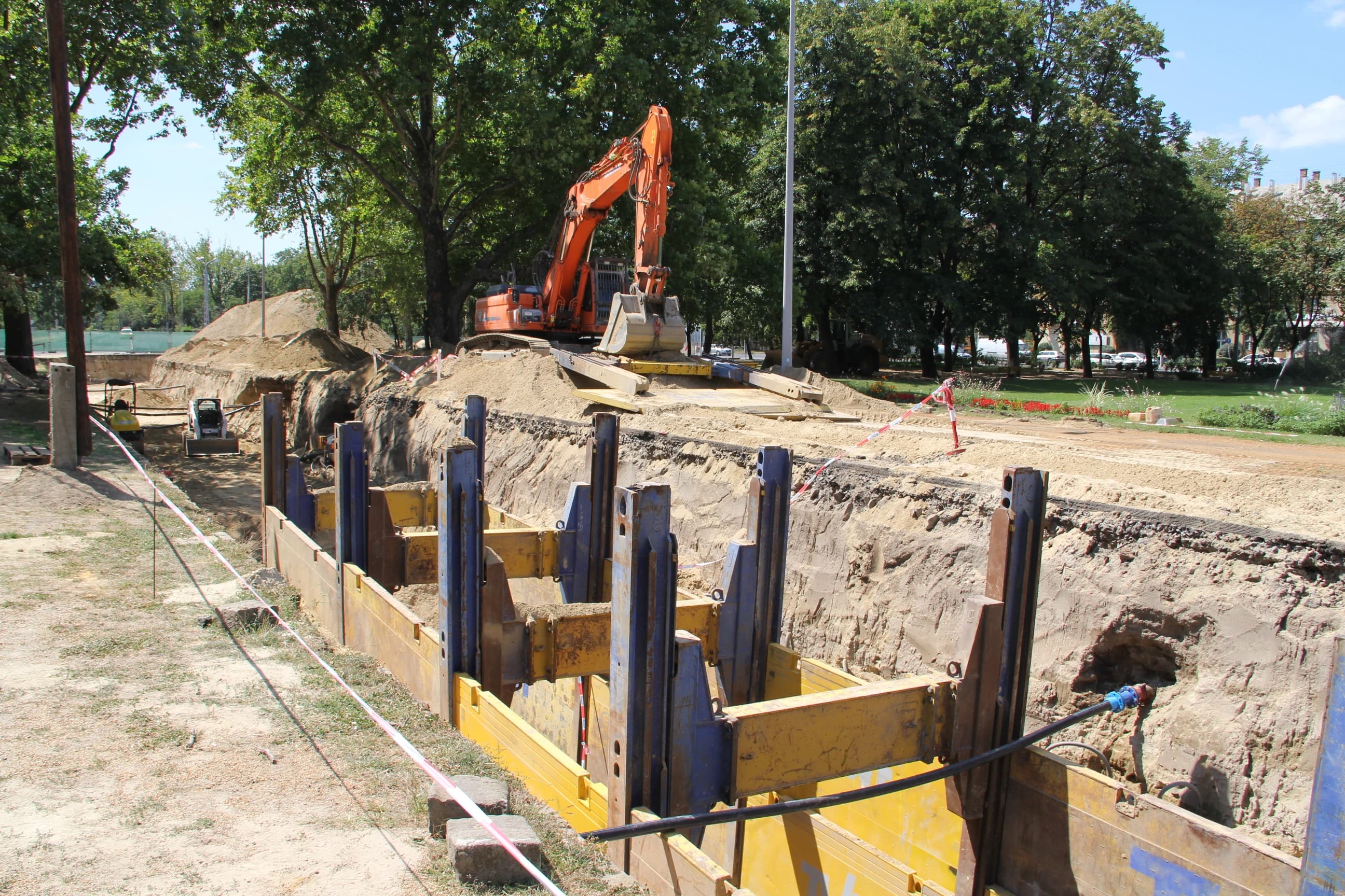 Munkagép és kivitelezői csapat terepi környezetben